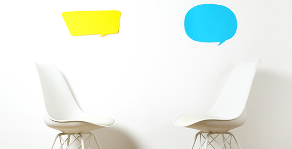 two chairs facing each other with word bubbles on the wall above them